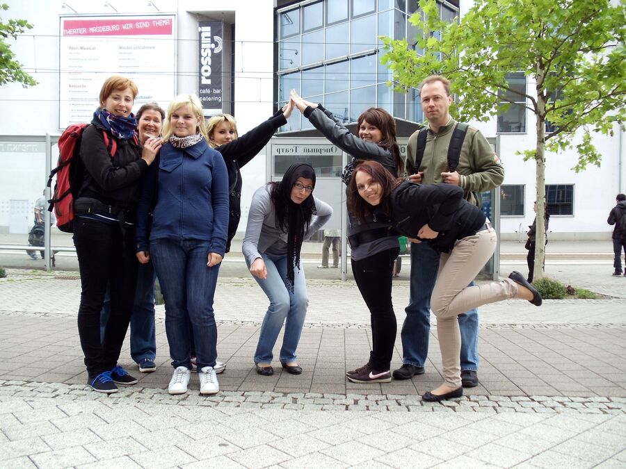 Teilnehmerinnen und Teilnehmer formen zum Spaß eine Figur in einer Fußgängerzone