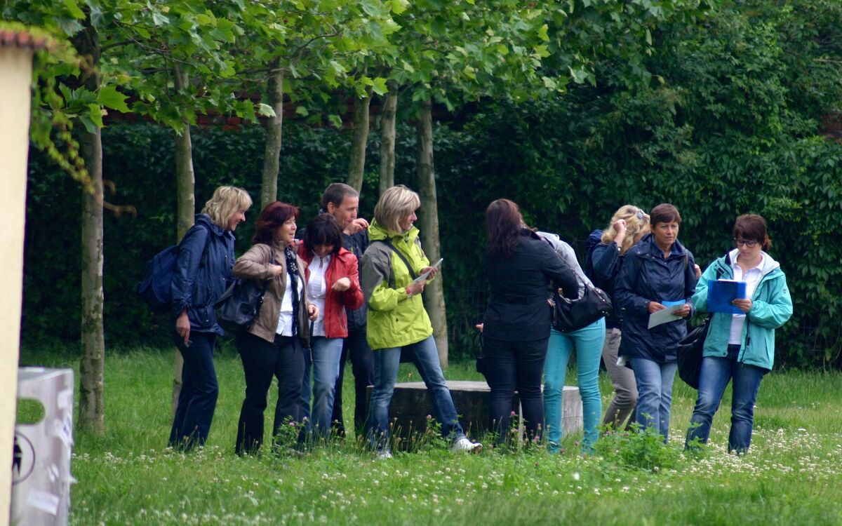 Teilnehmergruppe mit Karten bei einem Geocaching-Teamevent im Park